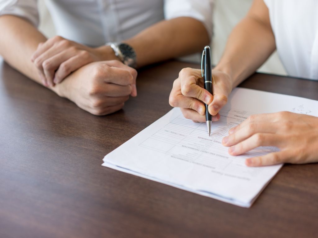 Photo of the hands of two people completing a document